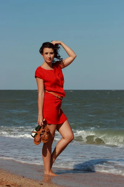 Beautiful woman walks at the sea side