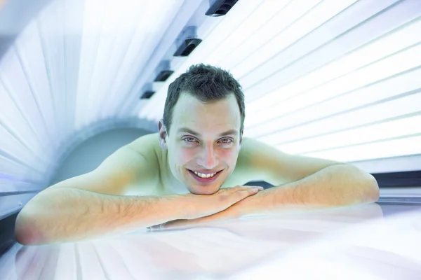 Handsome young man relaxing during a tanning session in a  solarium