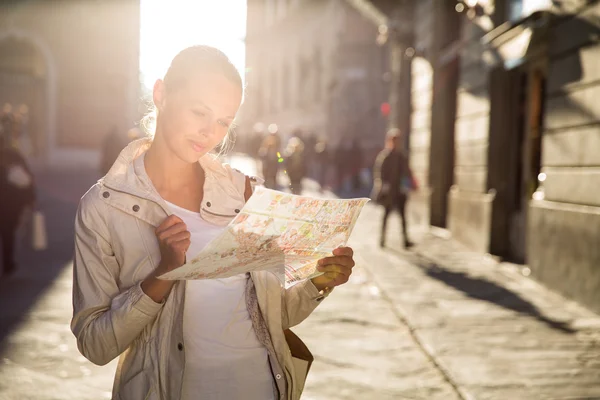 Gorgeous female tourist with a map discovering a foreign city