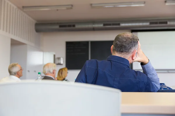 Elderly people are sitting in a classroom