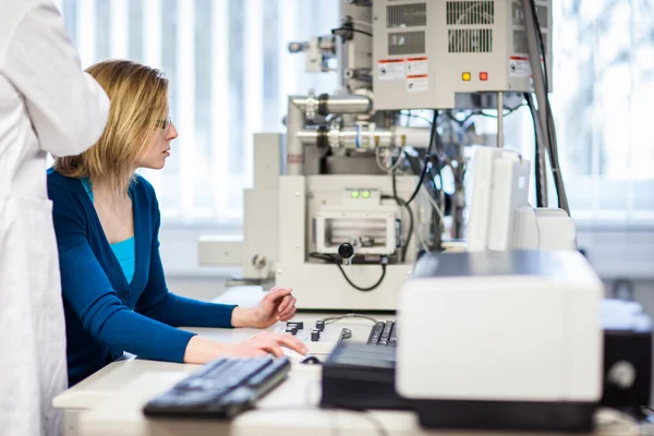 Female researcher using a microscope in a lab