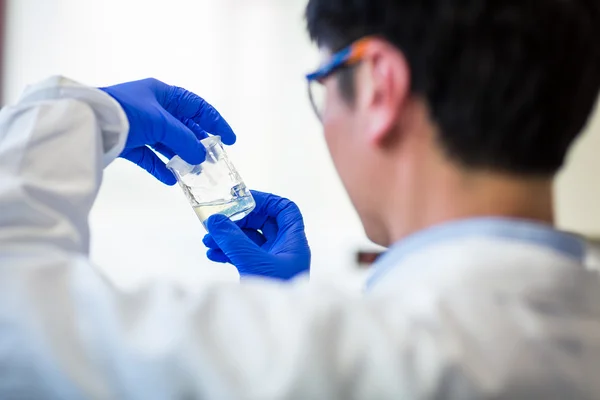 Male researcher carrying out research in a chemistry lab (color