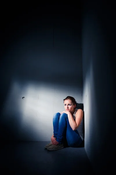 Young woman suffering from a severe depression (very harsh light