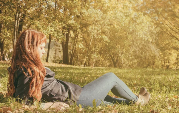 Beautiful woman with red hair in autumn park