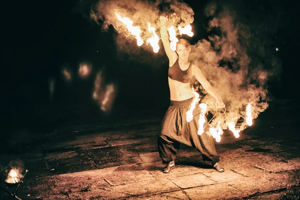 Active girls carries out tricks for fire show at night