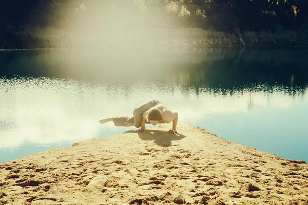Man practices asanas on yoga in harmony with nature