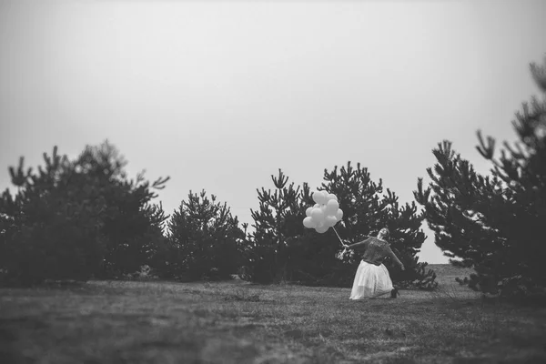 Unusual woman with balloons as concept outdoors