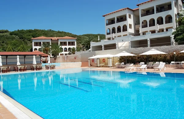 Pool and white buildings in Greek hotel.