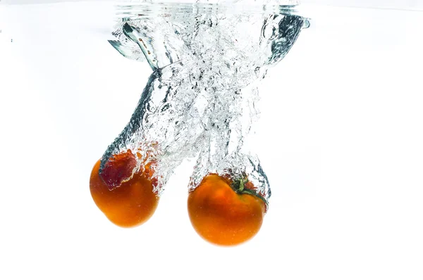 2 tomato fruits fall deeply under water