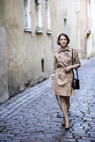 Woman at coat with handbag at her minds