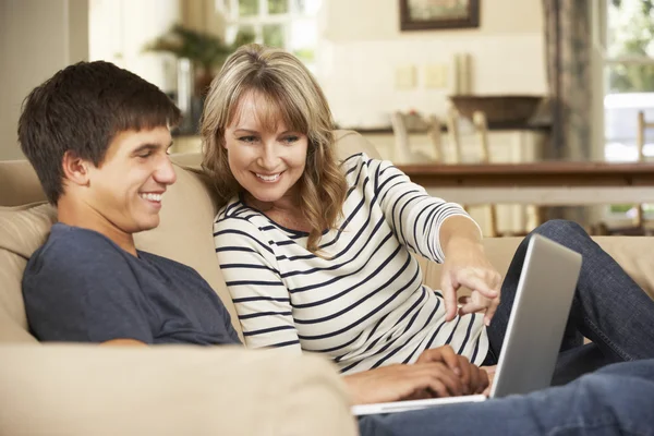 Mother With Teenage Son Using Laptop