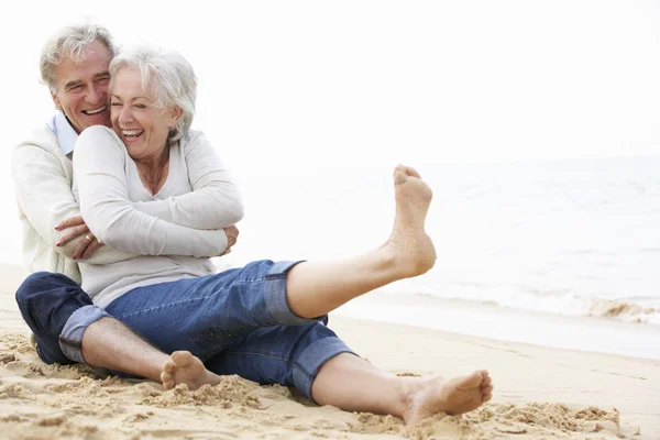 Senior Couple Sitting On Beach