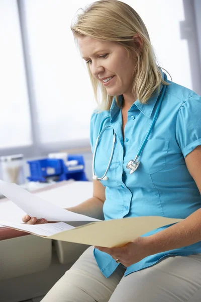 Female Doctor Reading Patient Notes