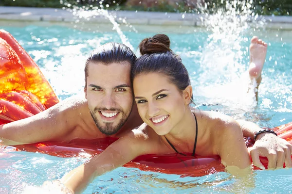 Couple Relaxing In Swimming Pool