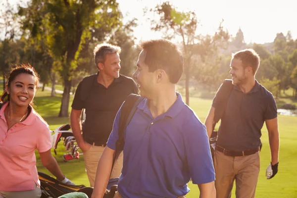 Group Of Golfers Carrying Golf Bags