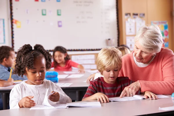 Senior teacher helping pupils in class