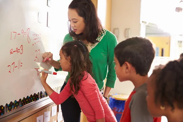 Pupil writing on the board at maths class