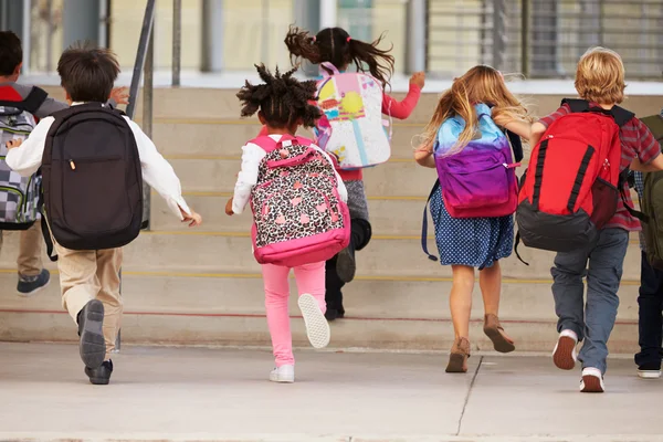 Elementary school kids running into school