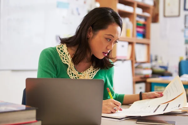 Female teacher marking student\'s work