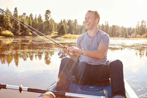 Man Fishing From Kayak On Lake