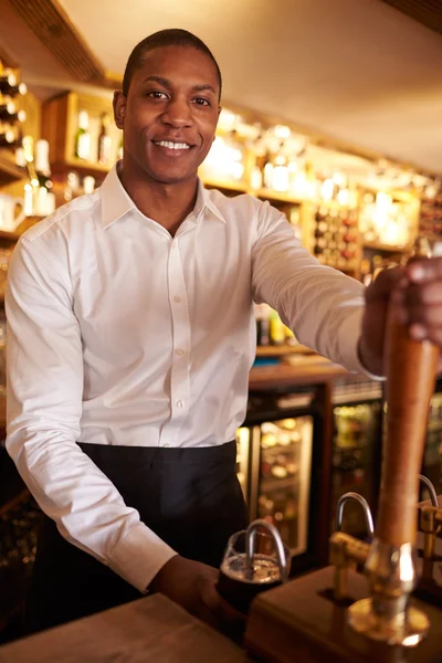 Man working behind a bar preparing drinks