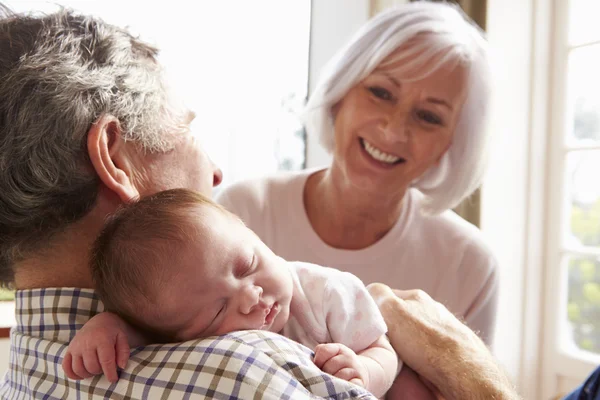 Grandparents Holding Sleeping Newborn