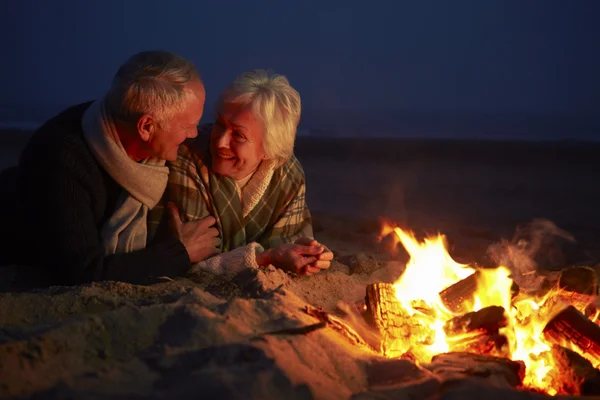 Senior Couple Sitting By Fire