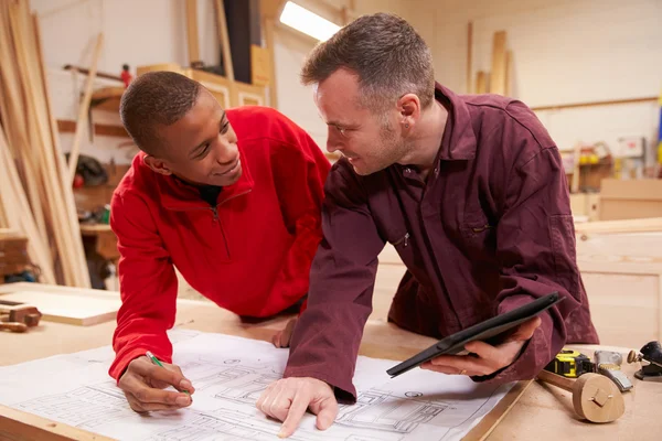 Carpenter With Apprentice In Workshop