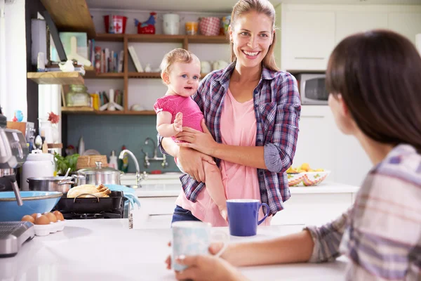 Mother With Daughter and Friend In Kitchen