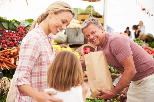 Family Buying Fresh Vegetables At Market