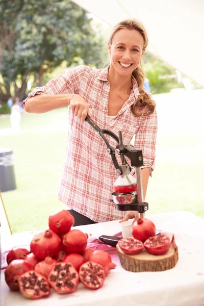 Woman Juicing Fresh Pomegranates At Market