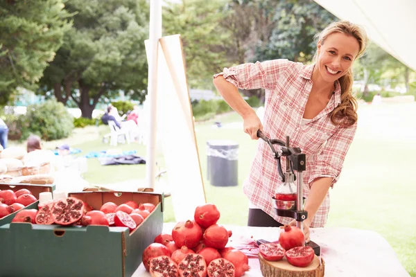 Woman Juicing Fresh Pomegranates At Market