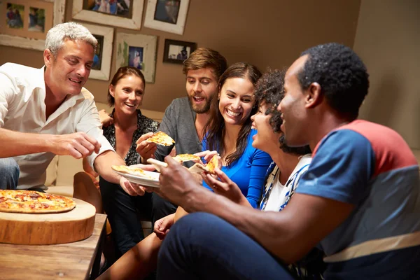 Friends eating pizza at a house party
