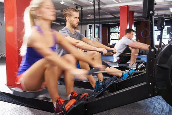 People Working Out On Rowing Machines