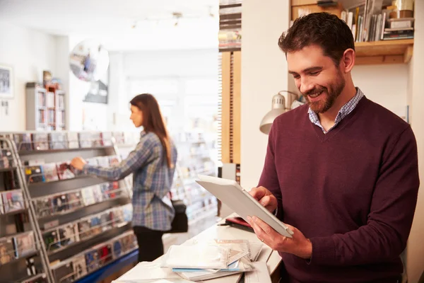 Man using digital tablet at a record shop