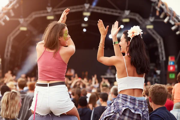 Two girls in the crowd at a music festival
