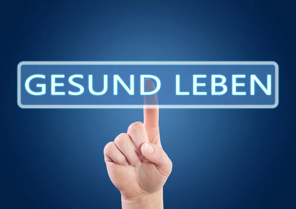 Gesund leben - german word for living well - hand pressing button on interface with blue background.