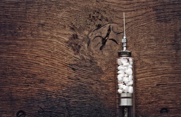 Obsolete glass syringe with pills form heart