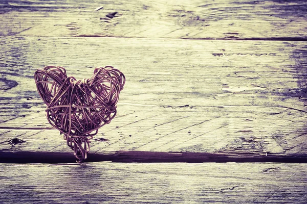 Braided wire heart on old wooden planks