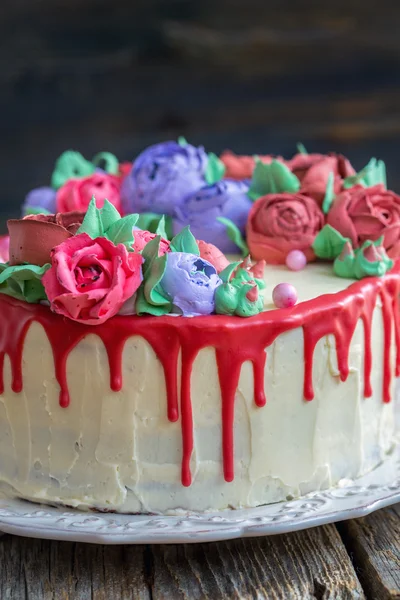 Cake with flowers and red chocolate icing.