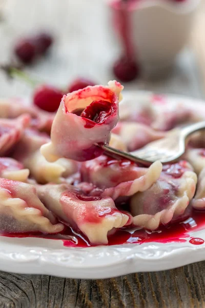 Dumplings with a cherry on a fork.