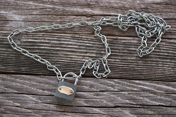 Padlock and chain on wooden background