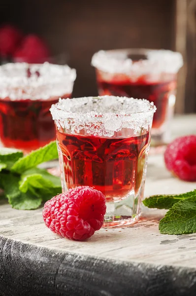 Red sweet cocktails with mint and raspberries