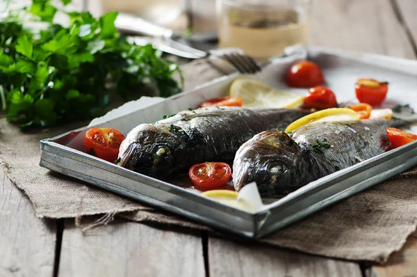 Cooked fish with parsley, tomato and lemon