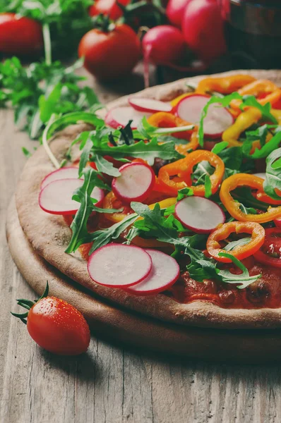 Vegan pizza with radish, tomato and paprika