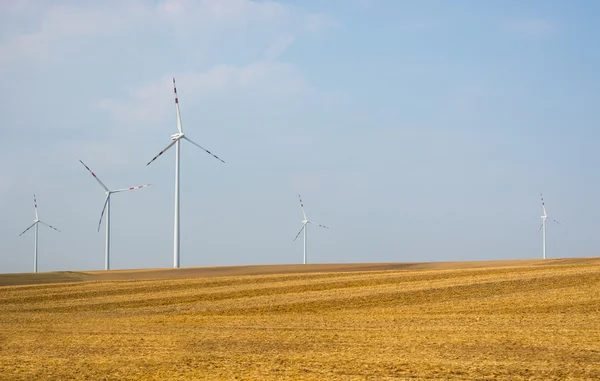 Fields and wind power stations on blue sky