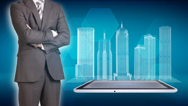 Businessman and wire-frame buildings on screen tablet