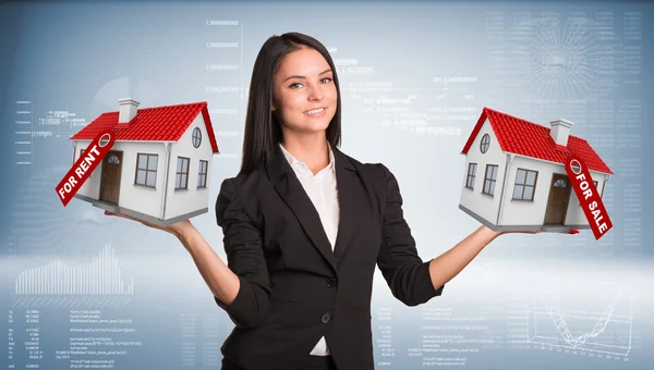 Businesswoman holding housees in hands