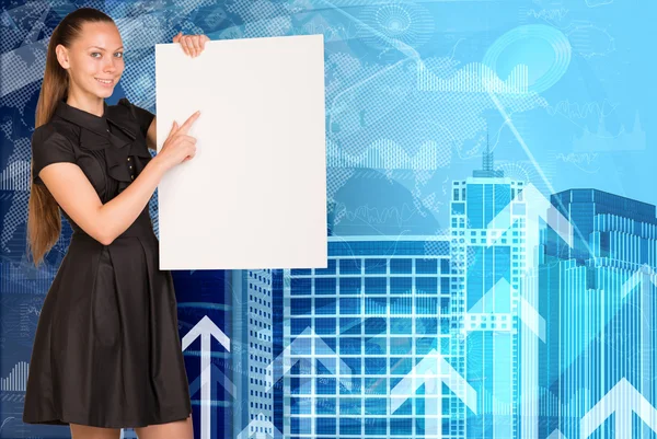 Beautiful businesswoman in dress holding empty paper sheet. Buildings and arrows as backdrop