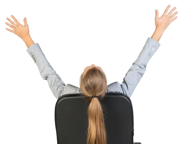 Businesswoman on office chair stretching her arms